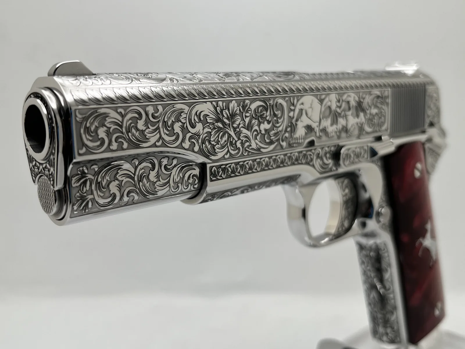 1911 with scroll and skull engraving and red pearl grips