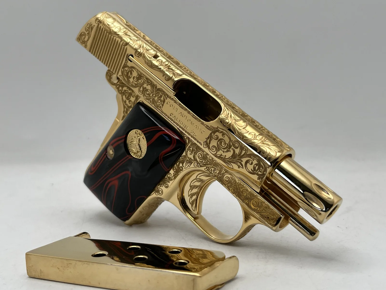 Colt pocket pistol with scroll engraving, black and red grips
